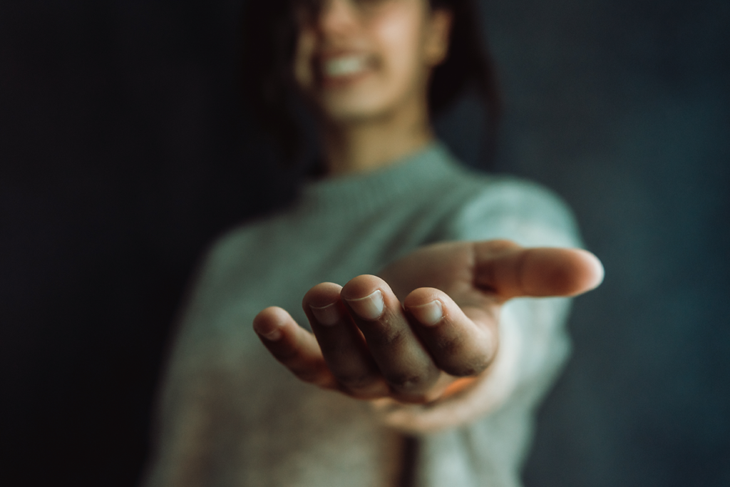 Smiling woman extending her hand as an offering of support tailored to specific learning difficulties SpLD